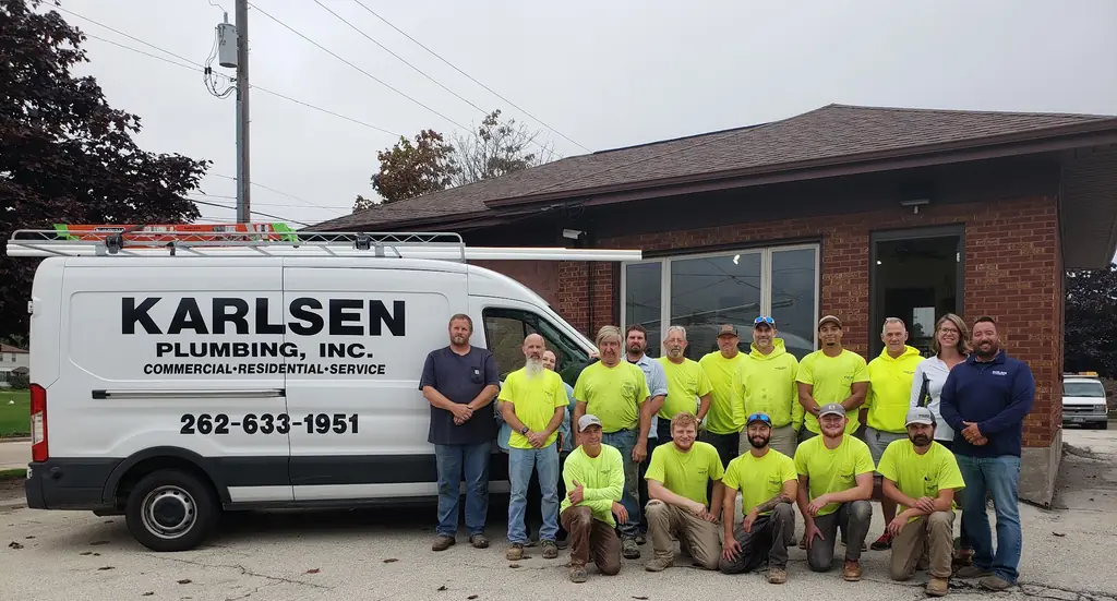 The Karlsen Plumbing crew in hi-vis shirts outside the Grove Avenue shop with a branded Karlsen Plumbing van